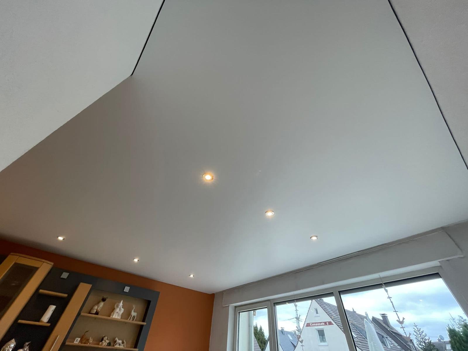 Moderne Satin-Spanndecke mit LED-Spots und sanfter Lichtreflexion